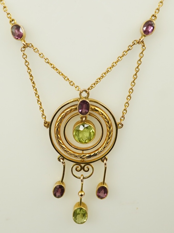 An Edwardian 9ct gold, peridot and garnet set drop pendant necklace, by Murrle Bennett & Co